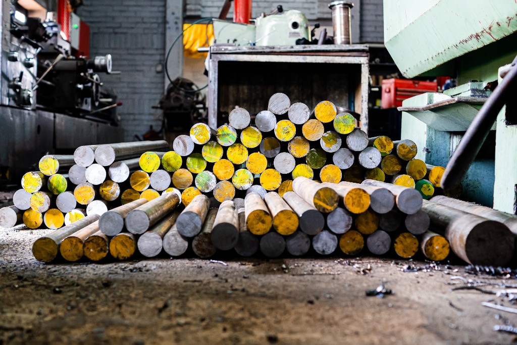 Stacked metal bar stock on the workshop floor at Titan Pumps SA