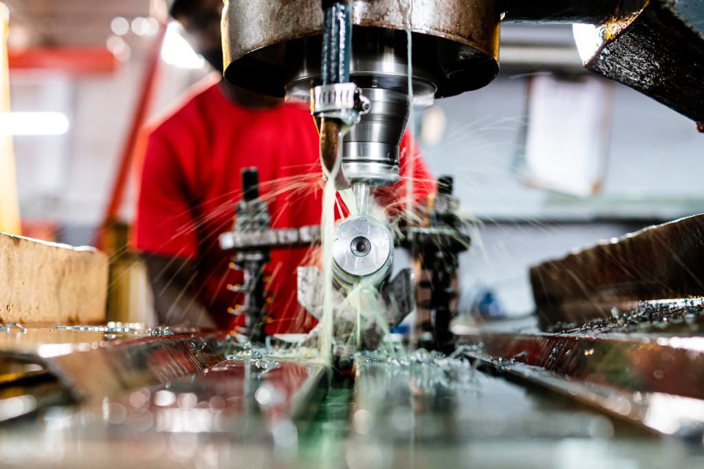 Industrial machining of a metal component with coolant spray in the Titan Pumps workshop, Orkney