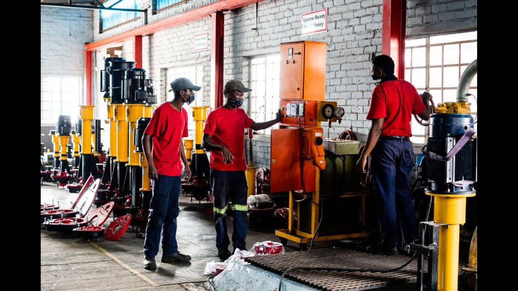 Titan Pumps SA workshop in Orkney: technicians working with industrial pumps, spares, and test equipment